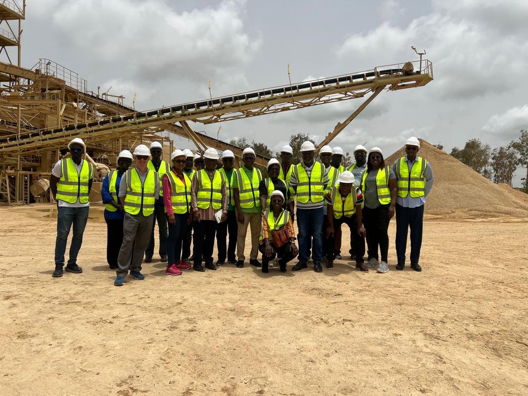 A group visiting an industrial site wearing safety equipment